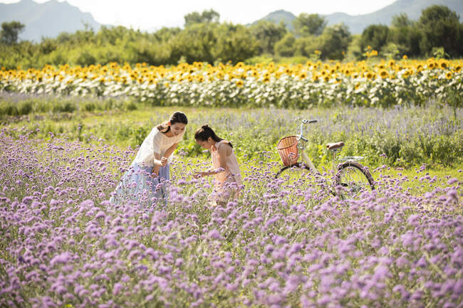 Chinese mother and daughter in flower field — Stock Photo