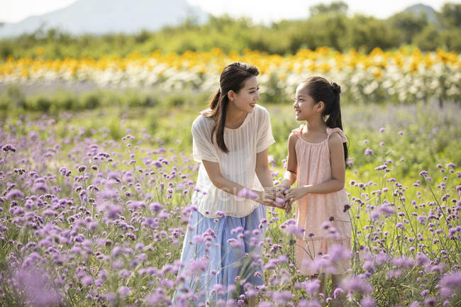 Китайська мати й дочка на квітковому полі. — стокове фото