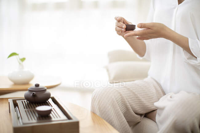 Підстрижена куля жінки з чаєм і чашечкою в руках. — стокове фото