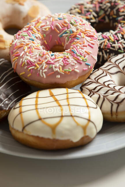 Köstliche Donuts mit verschiedenen Glasuren und Streusel — Stockfoto