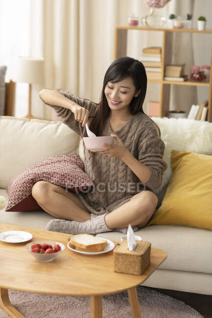 Молода китайка снідає вдома. — стокове фото