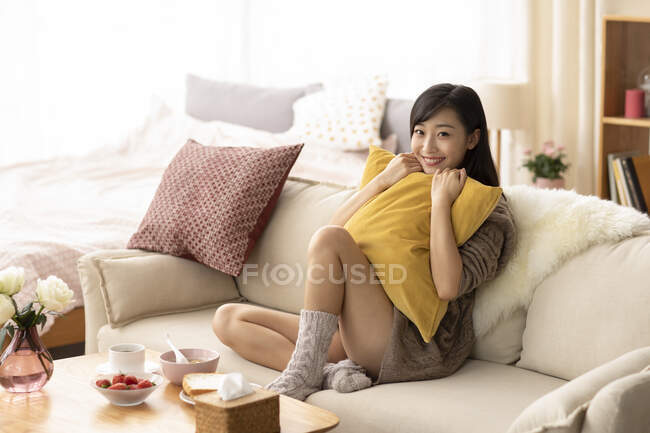 Young Chinese woman having breakfast at home — Stock Photo
