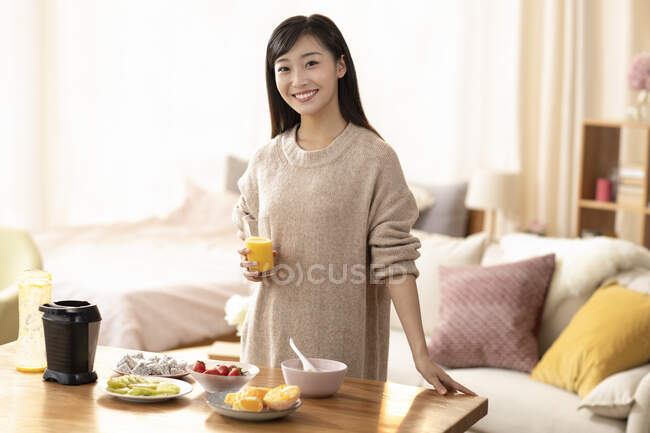 Молода жінка з свіжим апельсиновим соком. — стокове фото