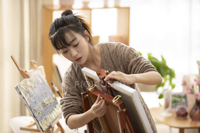Молода китайка готується до малювання вдома. — стокове фото