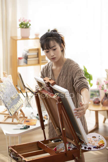Молода китайка готується до малювання вдома. — стокове фото