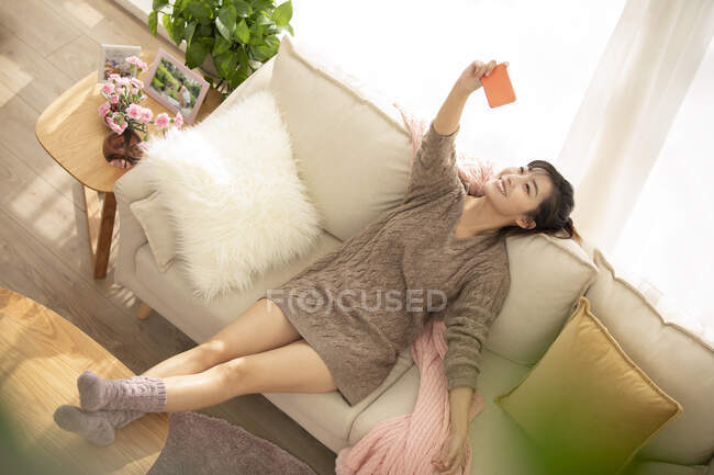Young Chinese woman doing live webcast at home — Stock Photo