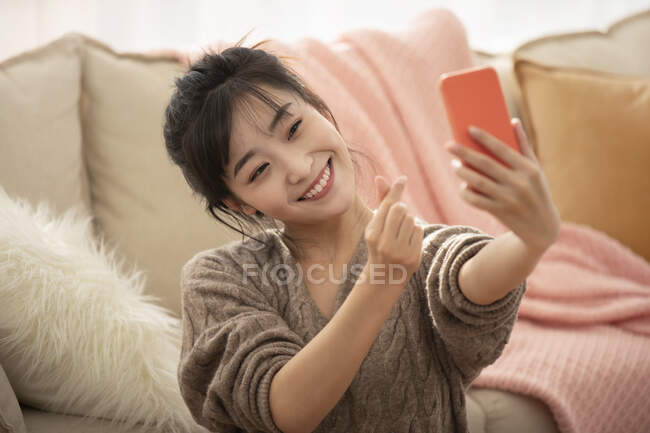 Молода китайка займається онлайн-кастингом вдома. — стокове фото