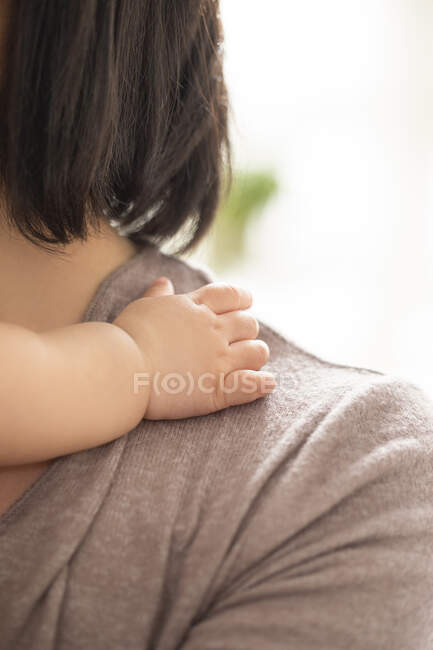 Babys hand on mothers shoulder, close up shot — Foto stock