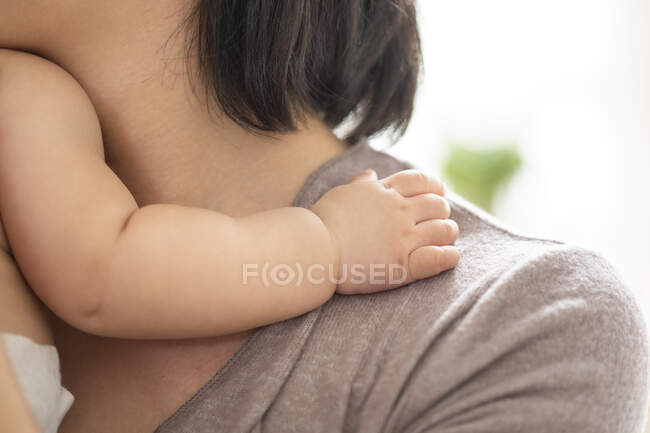 Babys hand on mothers shoulder, close up shot - foto de stock