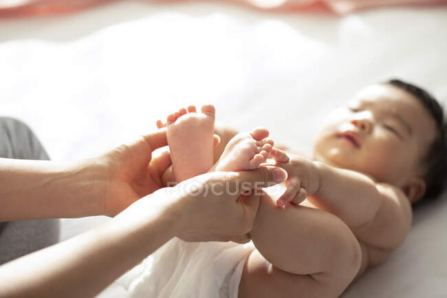 Plan recadré de la mère tenant les pieds du bébé — Photo de stock