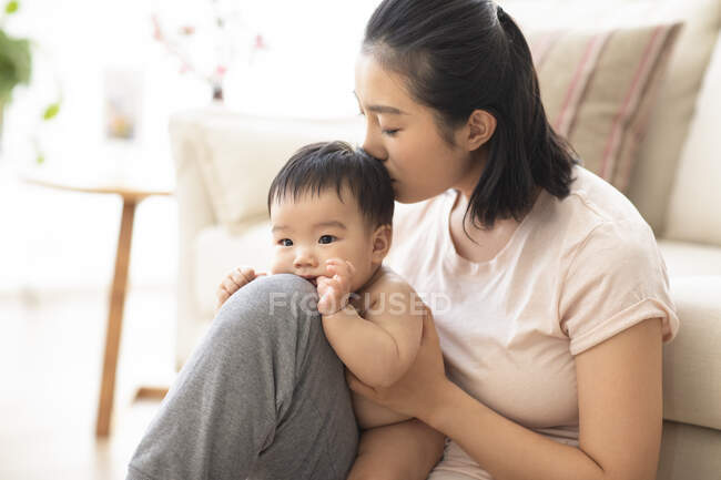 Ritratto della giovane madre che bacia il suo bambino — Foto stock