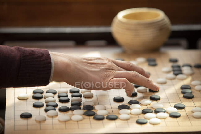 Schnittwunden an der Hand eines älteren Mannes beim Go-Spiel — Stockfoto