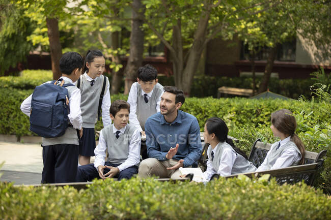 Profesor y estudiantes en el campus - foto de stock