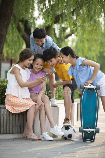 Teenagers using smartphone outdoors — Stock Photo