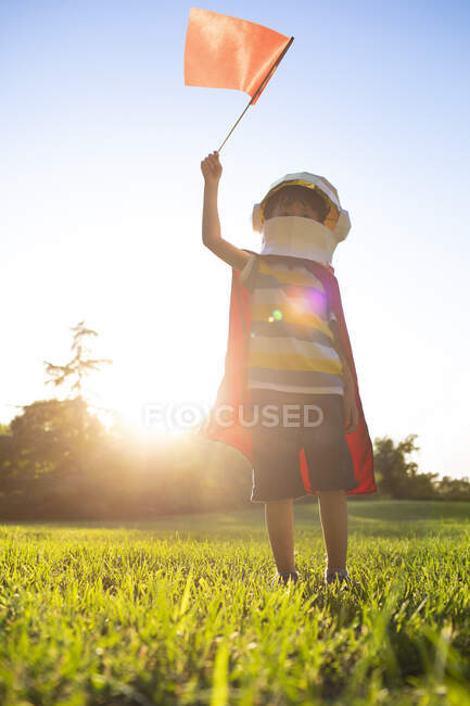 Маленький китайский мальчик в костюме играет на лугу — стоковое фото
