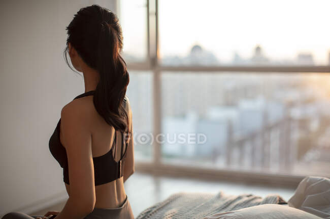 Visão traseira da jovem mulher em roupas esportivas na luz solar da manhã — Fotografia de Stock
