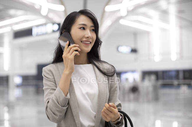 Jeune femme d'affaires parlant au téléphone à la station de métro — Photo de stock