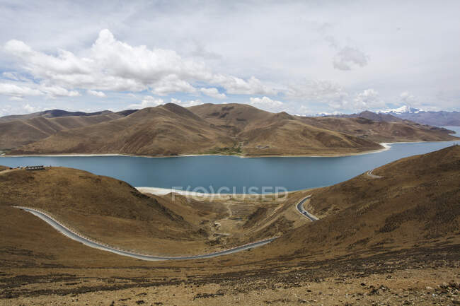 Ямдрокское озеро с холмами и облачным небом в Тибете, Китай — стоковое фото