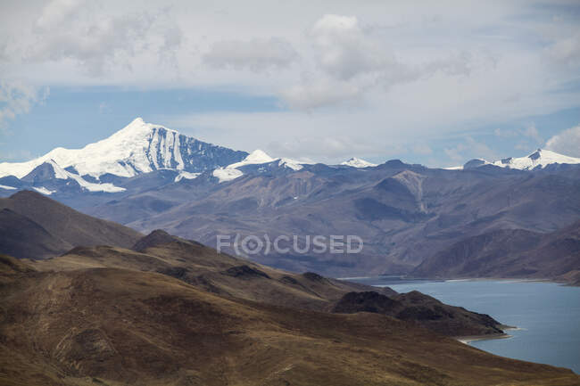 Montañas nevadas y lago Yamdrok en el Tíbet, China - foto de stock