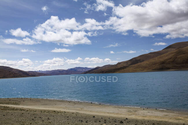 Lac Yamdrok avec collines et ciel nuageux au Tibet, Chine — Photo de stock