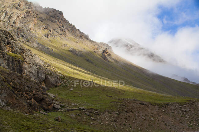 Мальовничий вид на гірський схил з низькими хмарами — стокове фото