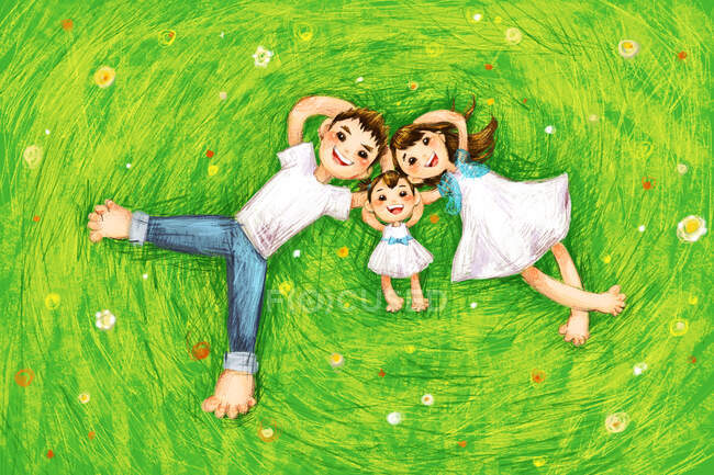 Happy family lying on green grass with flowers — Stock Photo