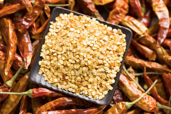 Chili seeds with dried whole peppers, close up shot — Stock Photo