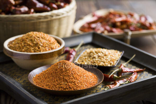 Chili pepper spices in bowls with dried peppers — Stock Photo