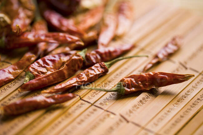 Dried Red chili peppers on bamboo mat — Stock Photo