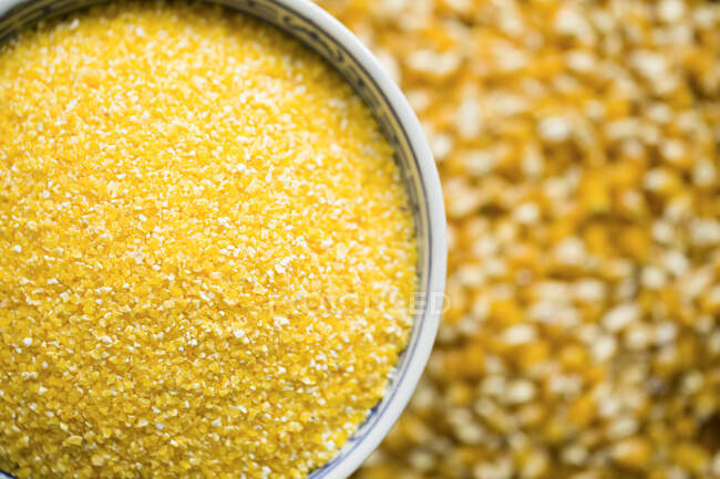 Milho ralado em tigela com sementes inteiras no fundo — Fotografia de Stock