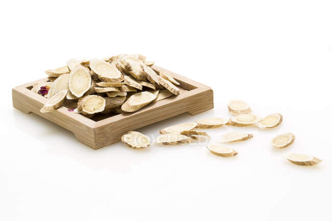 Traditional Chinese medicine, dried ginger slices on wooden tray — Stock Photo