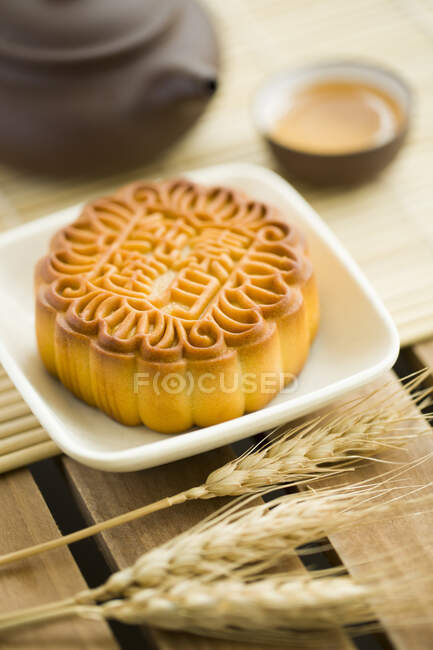 Pastel de luna chino tradicional con espiguillas en la mesa - foto de stock