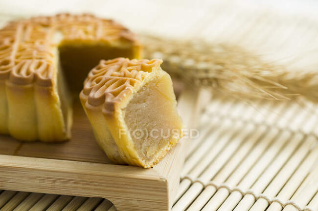 Mooncake with cut piece served on wooden plate — Stock Photo