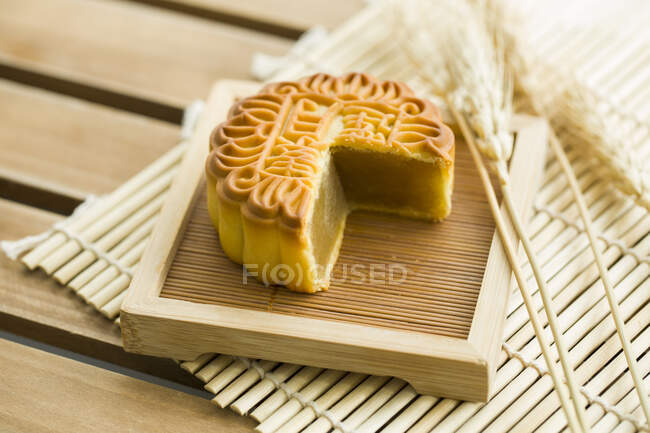 Mooncake with missing piece on wooden tray — Stock Photo