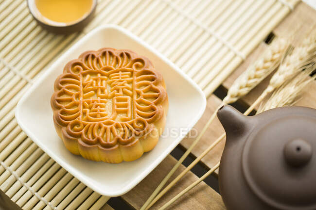 Mooncake, teapot and tea in cup on table — Stock Photo