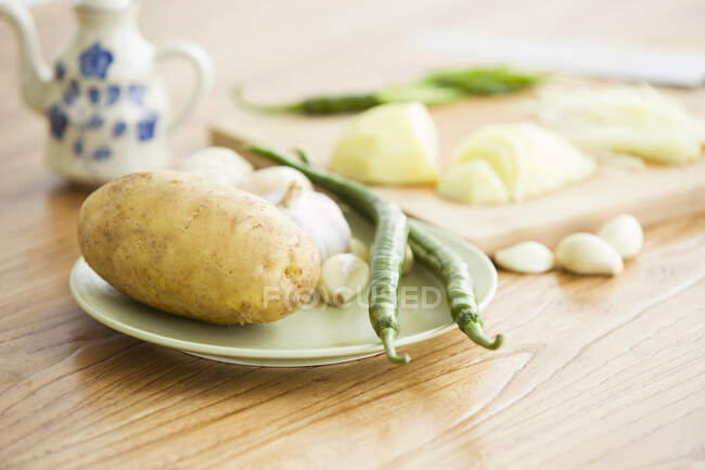 Papa con chiles verdes y ajo en el plato - foto de stock