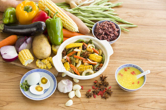 Assorted vegetables and cooked vegetable dish and sauce on table — Stock Photo
