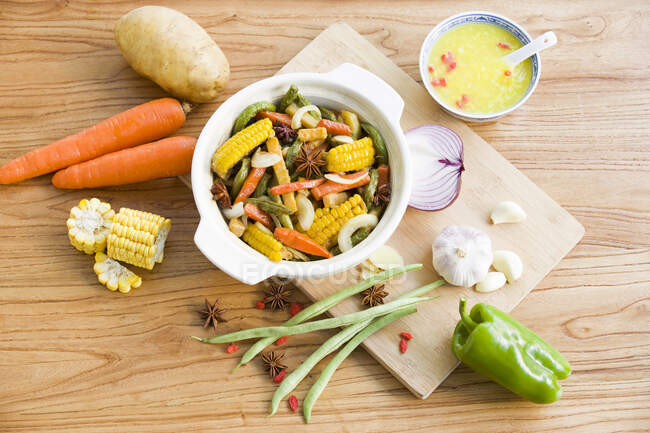 Surtido de verduras plato cocido con ingredientes en la mesa - foto de stock