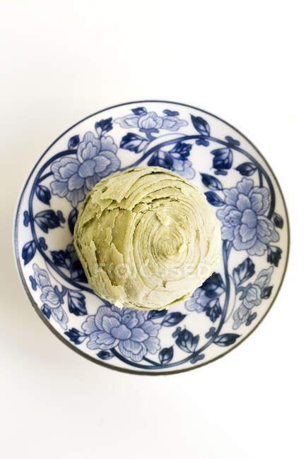 Té verde crujiente postre chino en plato con flores azules - foto de stock