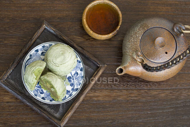 Matcha crisp desserts and tea in pot and cup — Stock Photo