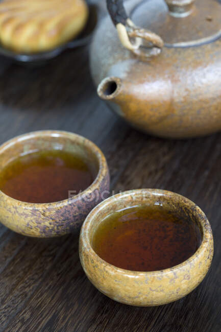 Teekanne und mit Tee gefüllte Tassen, Nahaufnahme — Stockfoto
