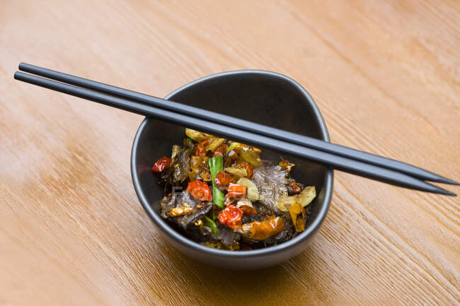 Plato chino, carne de res con chile en tazón y palillos en él - foto de stock