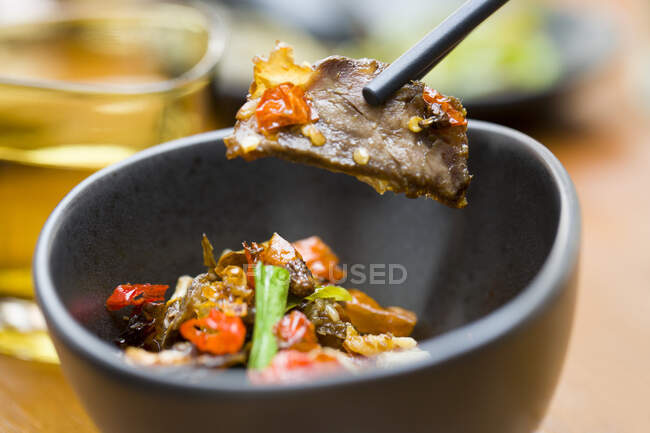 Plato chino, carne de res con chile en tazón y palillos - foto de stock