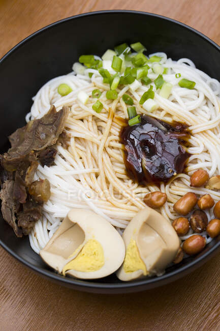 Chinesische Nudeln, Nudeln mit verschiedenen Zutaten und Sauce in Schüssel serviert — Stockfoto