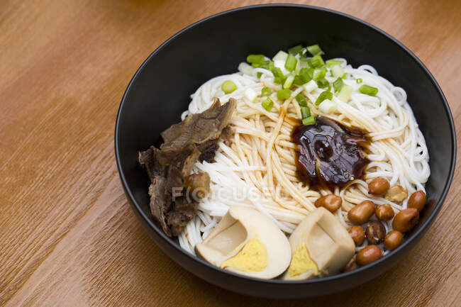 Macarrão chinês, macarrão com vários ingredientes e molho servido em tigela — Fotografia de Stock