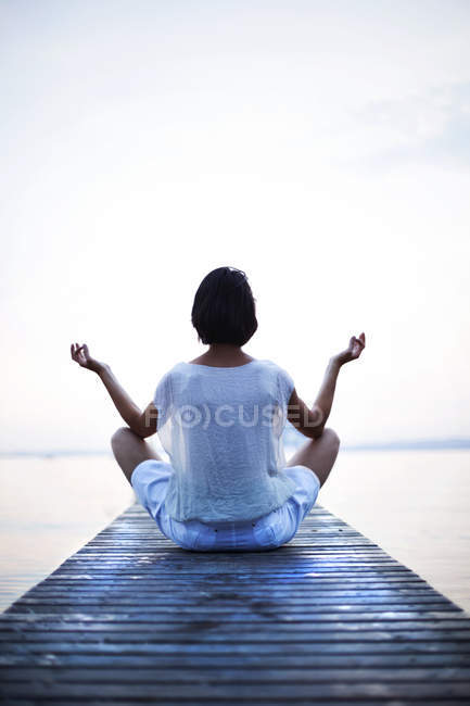 Donna che fa yoga di fronte al mare — Foto stock