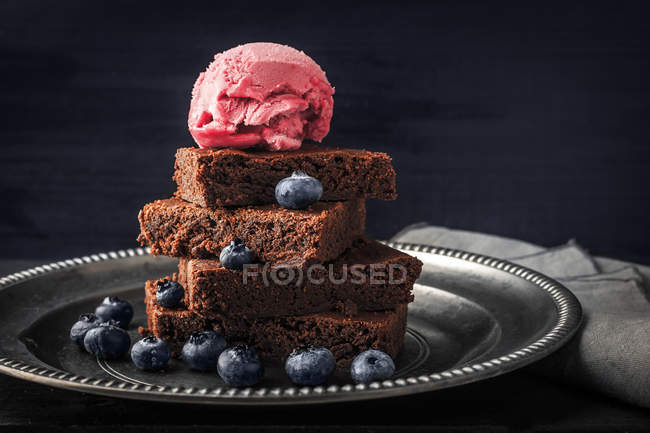 Schokoladenbrownie mit Blaubeere und Eis auf dem horizontalen Vintageteller — Stockfoto