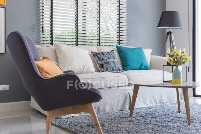 Современная гостиная с современным креслом и диваном с вазой растения — стоковое фото