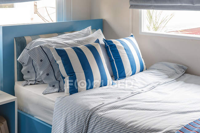 Quarto de criança moderna com cama azul e azul almofadas tom de cor — Fotografia de Stock