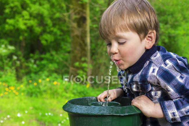 Carino bambino bere da una fontana — Foto stock